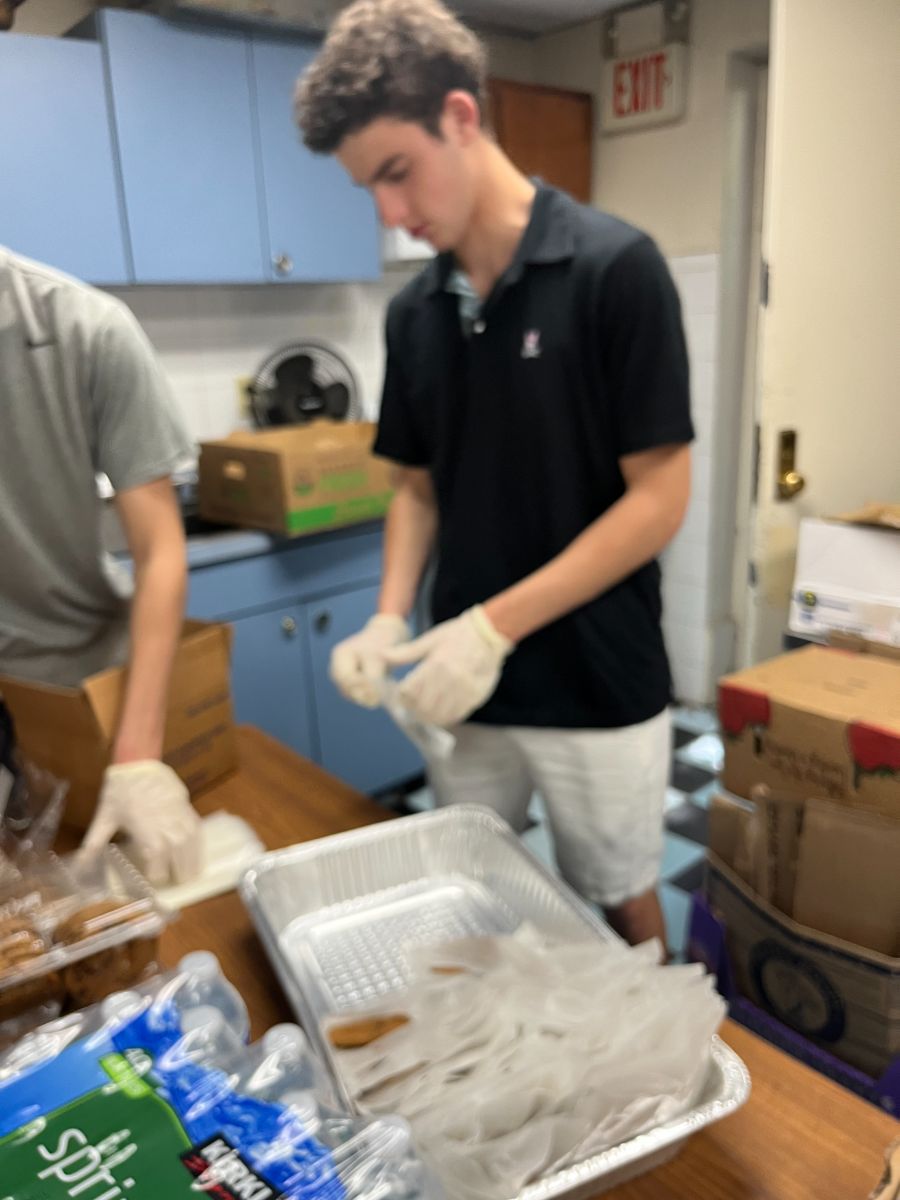 Founders packing meals with cases of water at the kitchen
